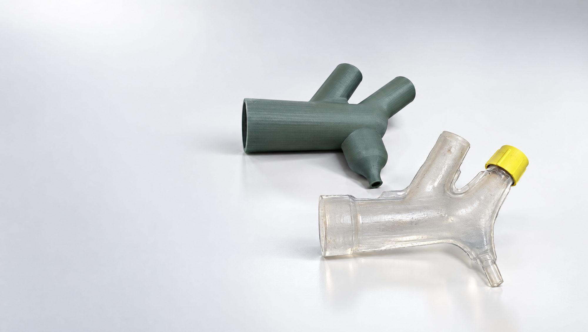 A clear printed vessel model beside its silicone cast