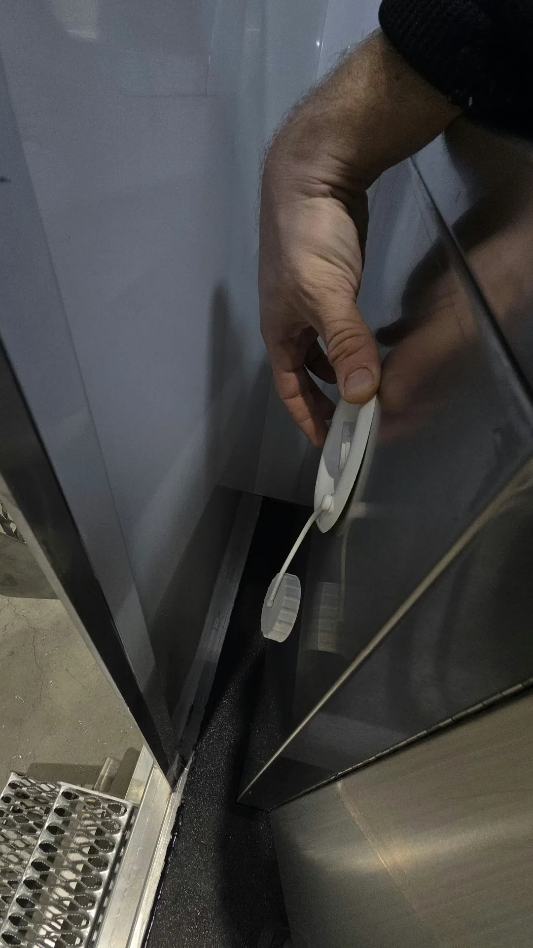 Mains plaçant des cibles de numérisation circulaires sur une surface métallique.