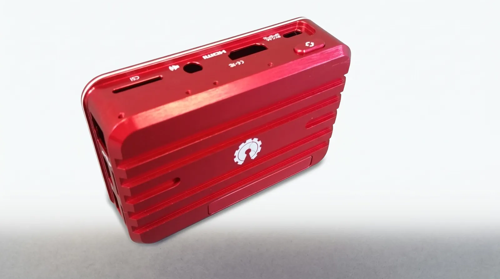 Project photograph of a red machined aluminium enclosure with ribs and labelled port openings.