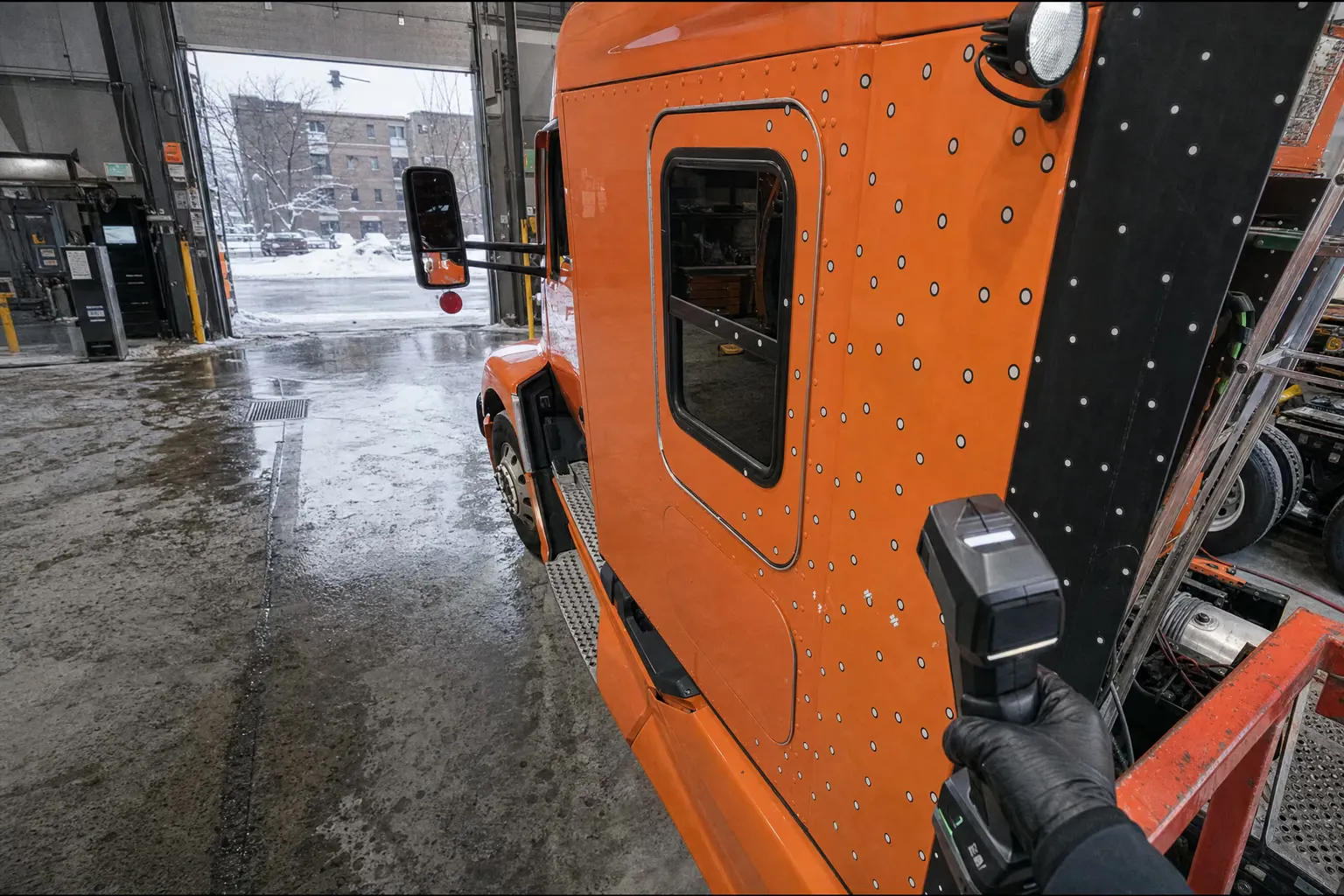 Numérisation 3D portative d'une cabine de camion orange couverte de cibles de numérisation dans un garage de Montréal